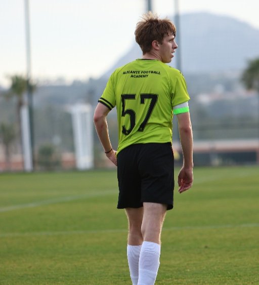 Alicante Football Academy player number 57 with captain armband on football pitch