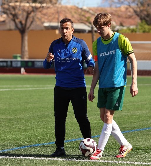 alicante football academy coach guiding player during training
