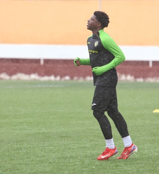 alicante football academy player running in rain training session