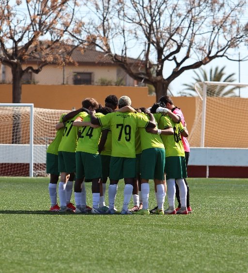 alicante football academy players in team huddle on pitch