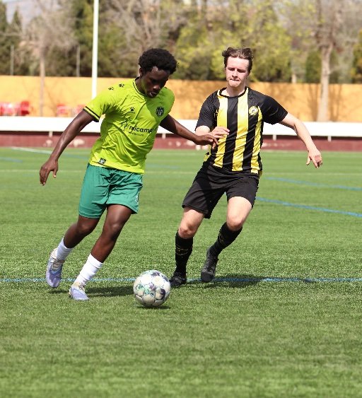 football academy player dribbling past defender