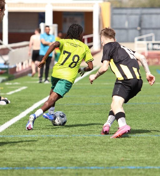 soccer player dribbling past an opponent on the wing