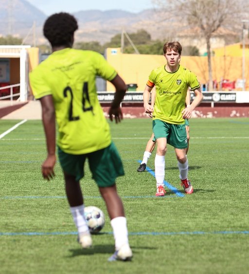 soccer player practising a short pass on the pitch