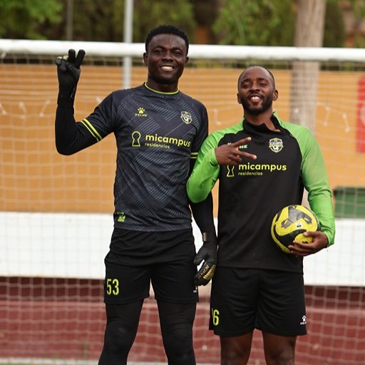 alicante football academy goalkeeper with teammate holding football