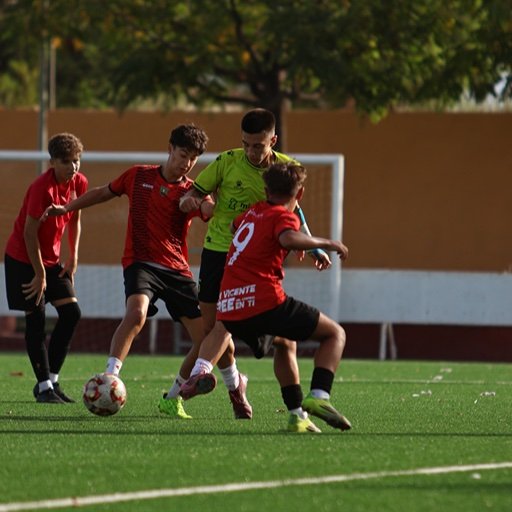 young football players competing for ball during training