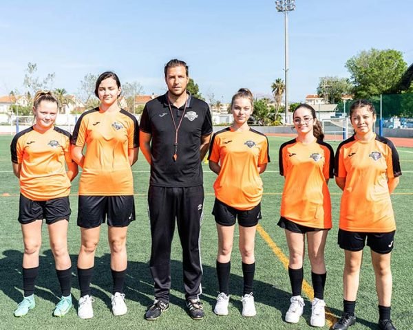 women in a football academy and coach